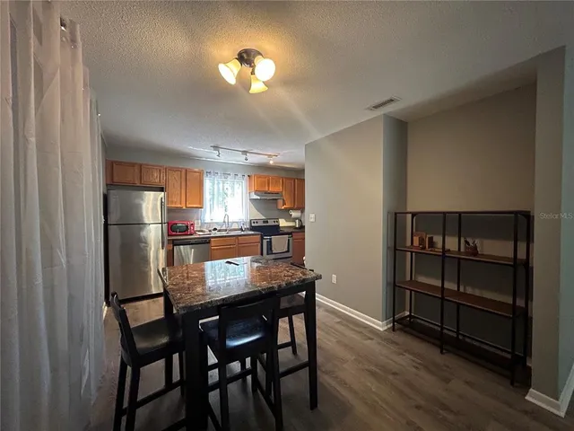 a kitchen with a dining table chairs refrigerator and cabinets