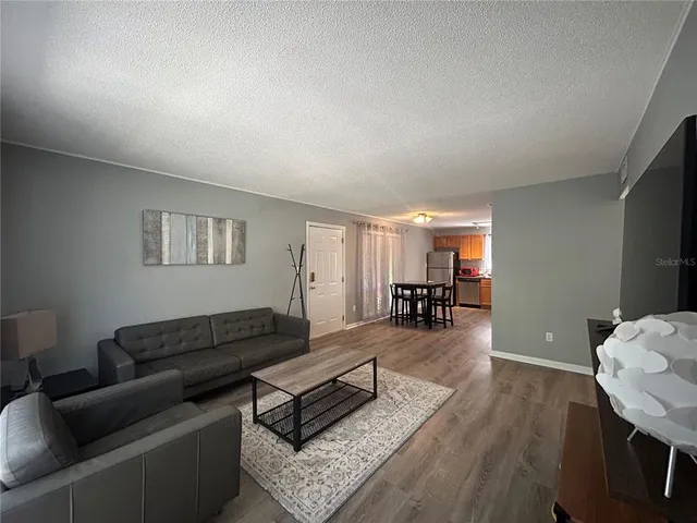 a living room with furniture and wooden floor
