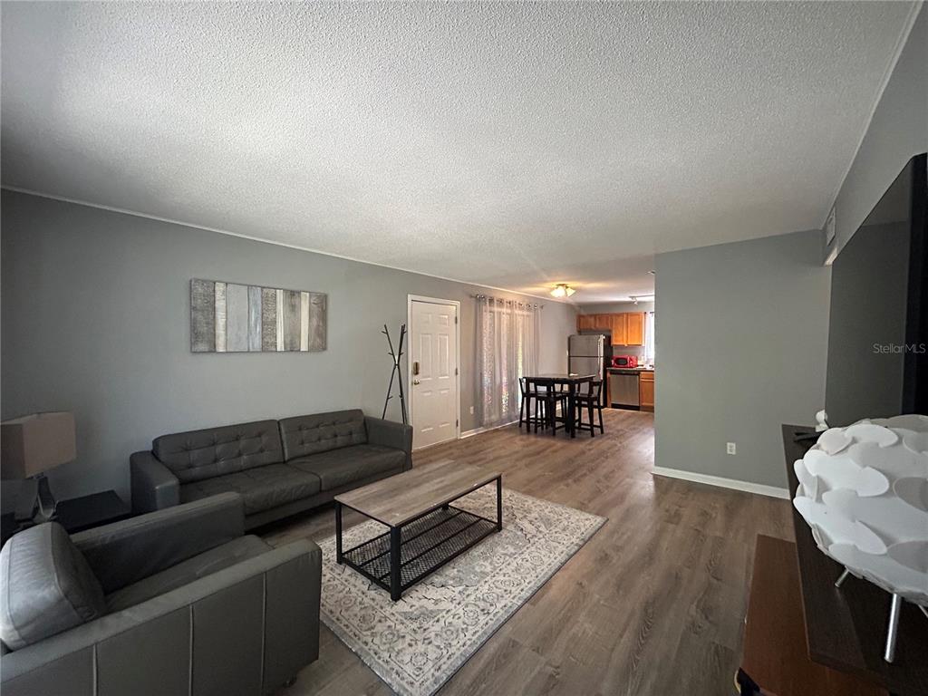 507 Northwest 39th Road, Unit 221 Gainesville, FL 32607 - Photo 2 of 19 a living room with furniture and wooden floor