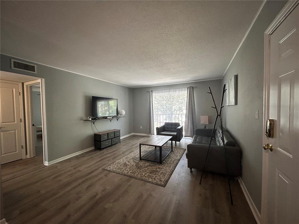 507 Northwest 39th Road, Unit 221 Gainesville, FL 32607 - Photo 5 of 19 a living room with furniture and a flat screen tv