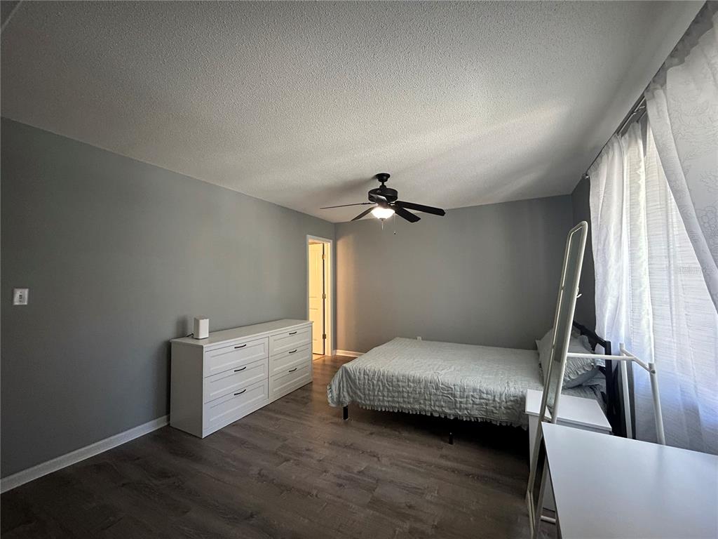 507 Northwest 39th Road, Unit 221 Gainesville, FL 32607 - Photo 8 of 19 a bedroom with a bed and a flat tv screen on the dresser