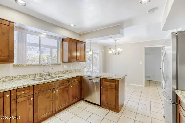 a kitchen with stainless steel appliances granite countertop a sink and a refrigerator
