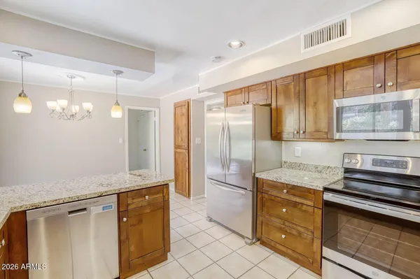 a kitchen with granite countertop a stove top oven microwave and cabinets