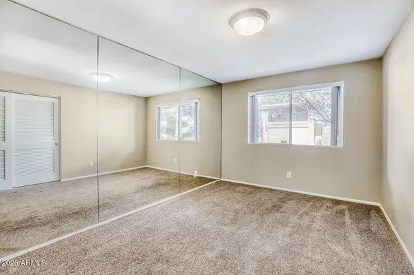 a view of a livingroom with a chandelier fan and windows