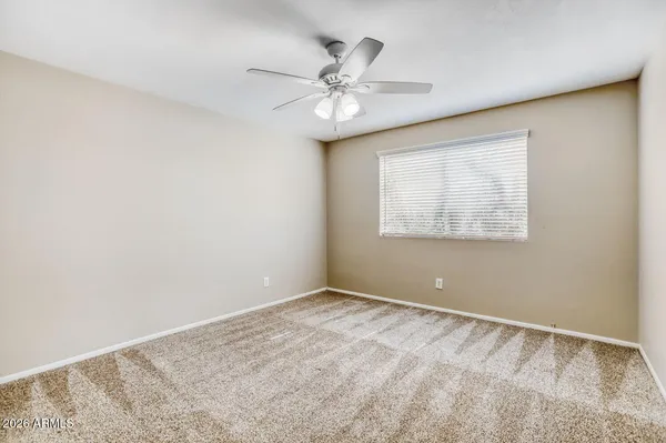a view of an empty room and a ceiling fan