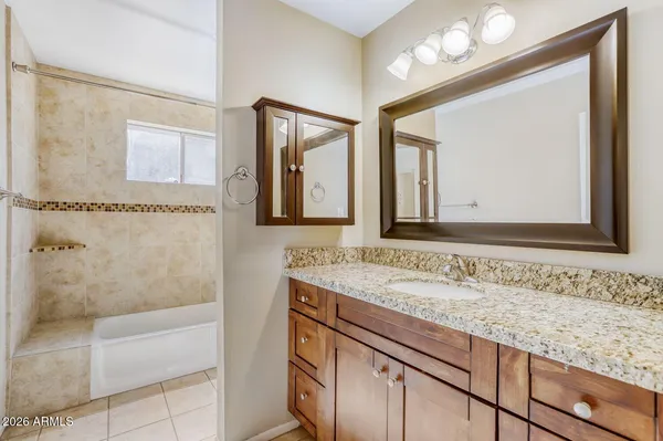 a bathroom with a granite countertop sink a toilet and shower