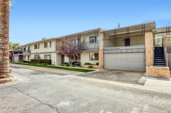 a front view of a building with a garden and plants