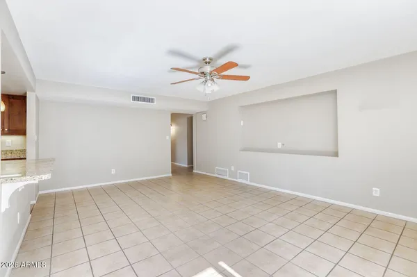 a view of a livingroom with a chandelier fan and windows