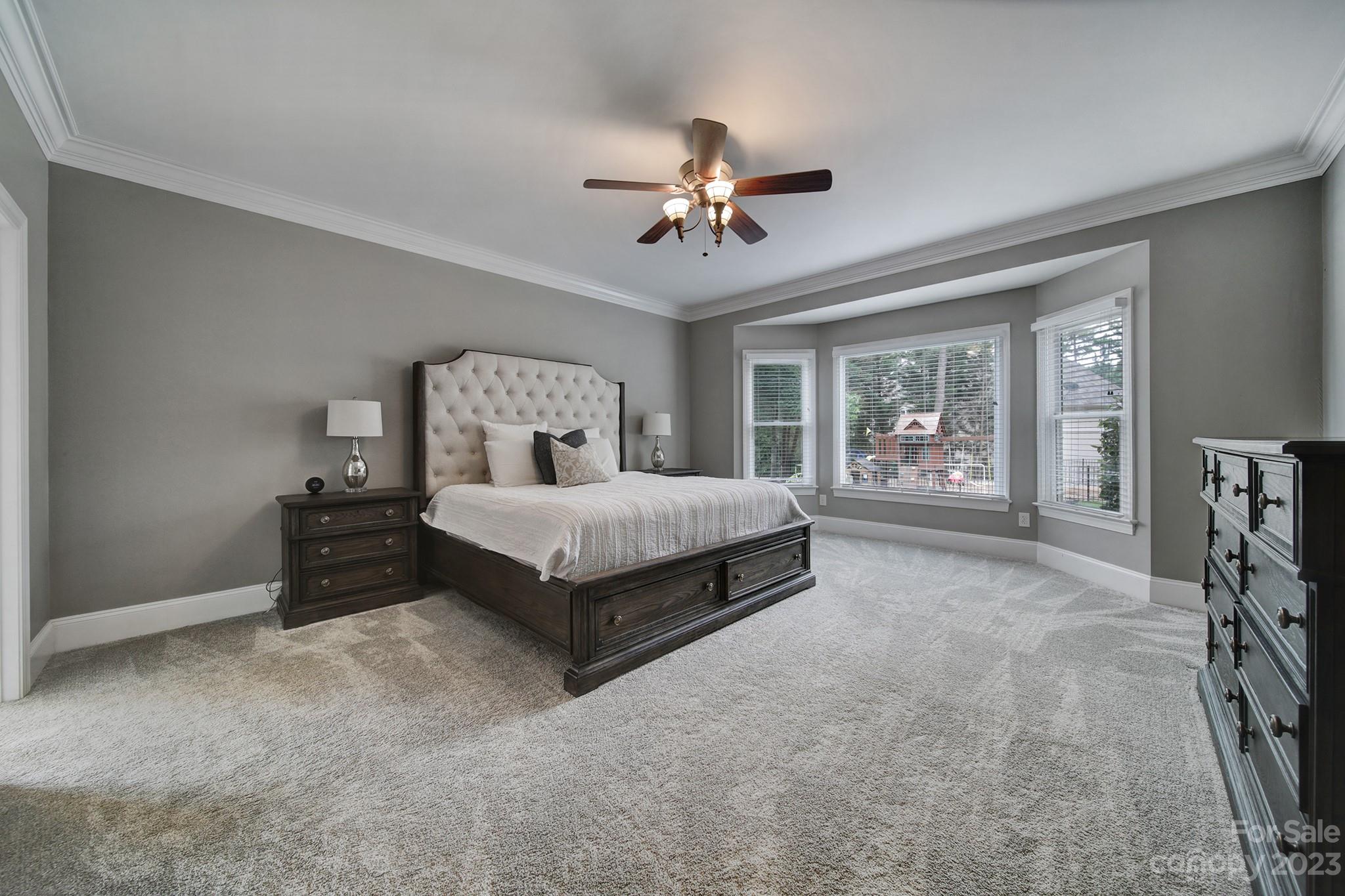 112 Old Post Road Mooresville, NC 28117 - Photo 12 of 42 a spacious bedroom with a bed a table and a chandelier
