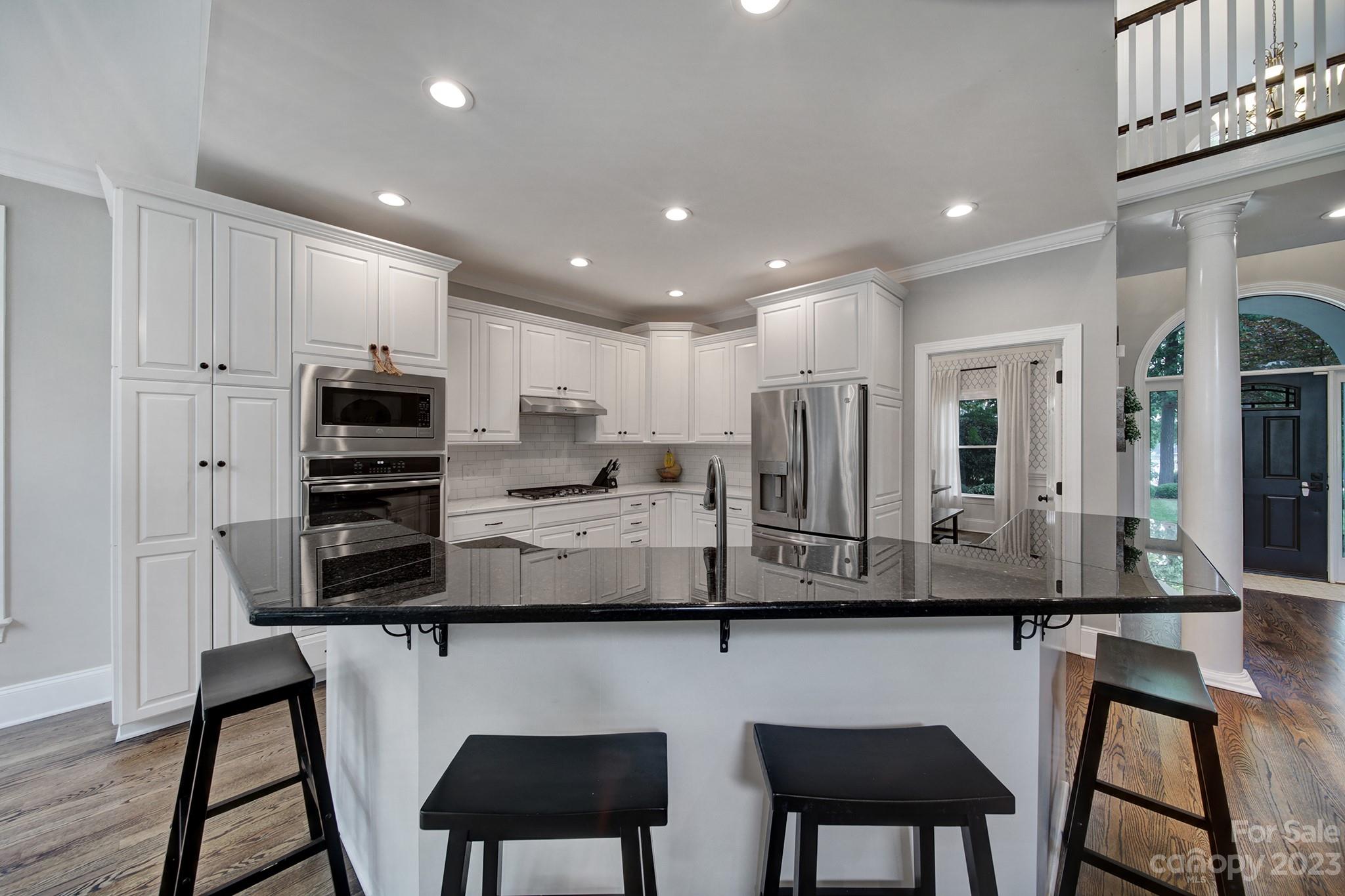 112 Old Post Road Mooresville, NC 28117 - Photo 3 of 42 a kitchen with stainless steel appliances granite countertop a table chairs microwave and refrigerator