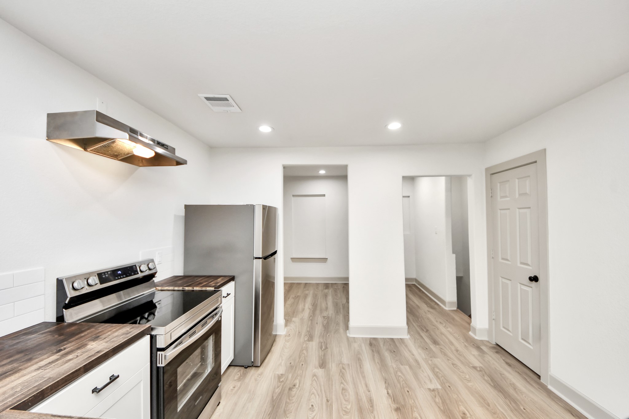 2919 Rosedale Street, Unit B Houston, TX 77004 - Photo 15 of 35 a view of a kitchen with wooden floor and electronic appliances