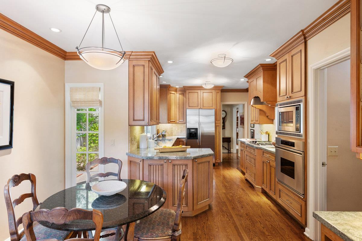 549 Edgewood Road San Mateo, CA 94402 - Photo 13 of 44 a kitchen with granite countertop a stove a sink a dining table and chairs