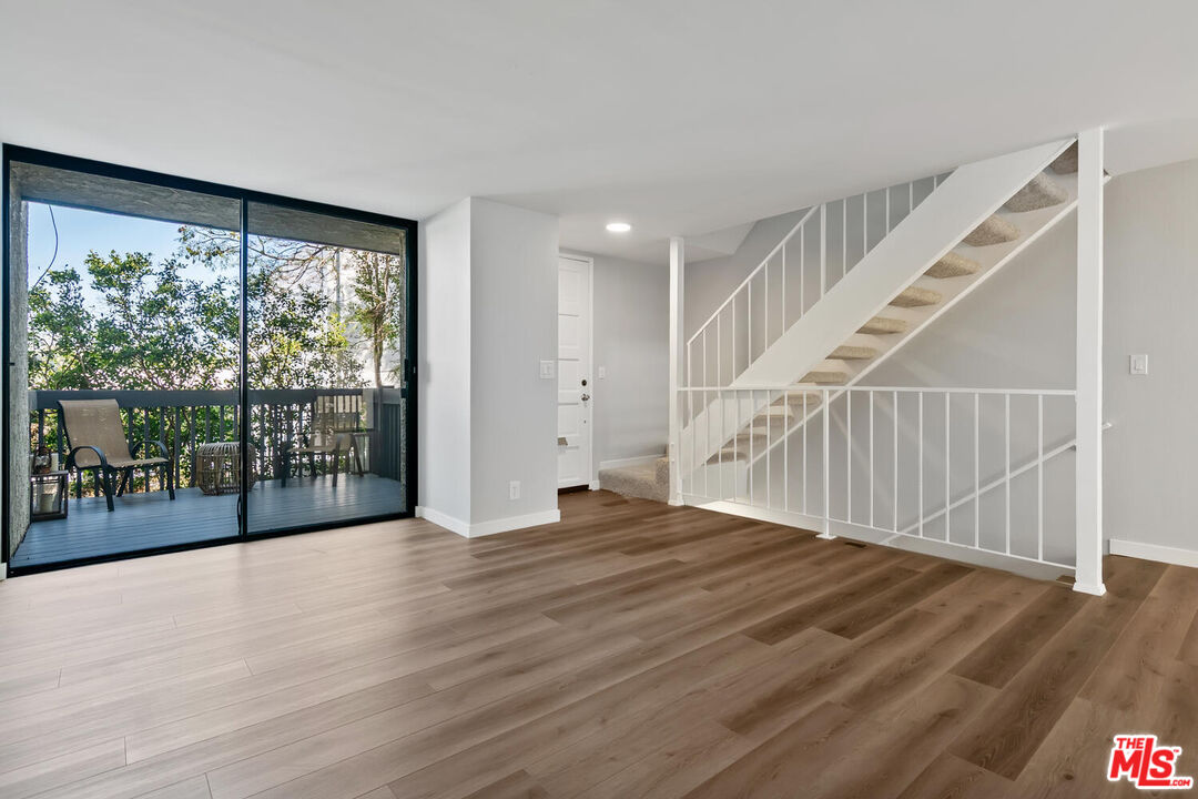 29239 Heathercliff Road, Unit 12 Malibu, CA 90265 - Photo 7 of 32 a view of an empty room with wooden floor and a window