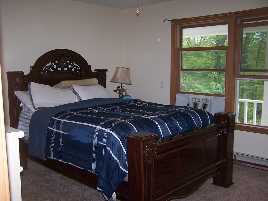 1388 Brimfield Road Warren, MA 01010 - Photo 7 of 21 a bed sitting in a bedroom next to a window