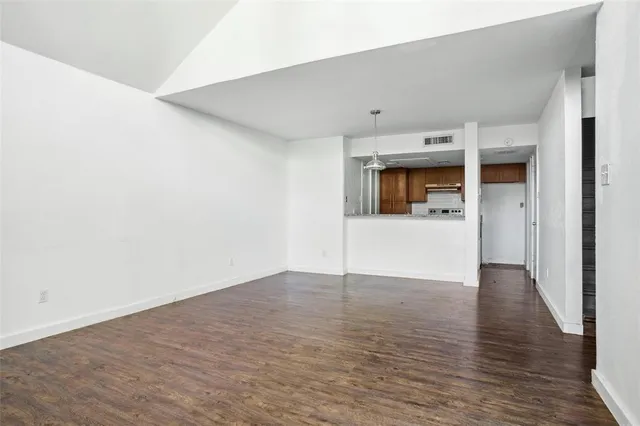 a view of empty room with wooden floor and sink