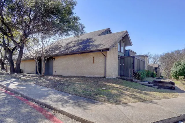 a view of a house with wooden fence and potted plants