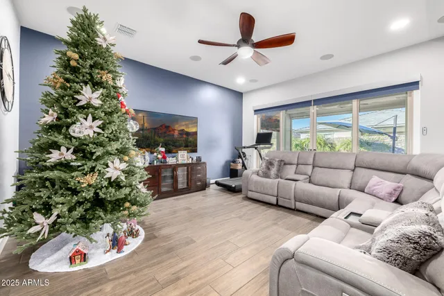 a kitchen with stainless steel appliances granite countertop a refrigerator a sink dishwasher a stove a dining table and chairs with wooden floor