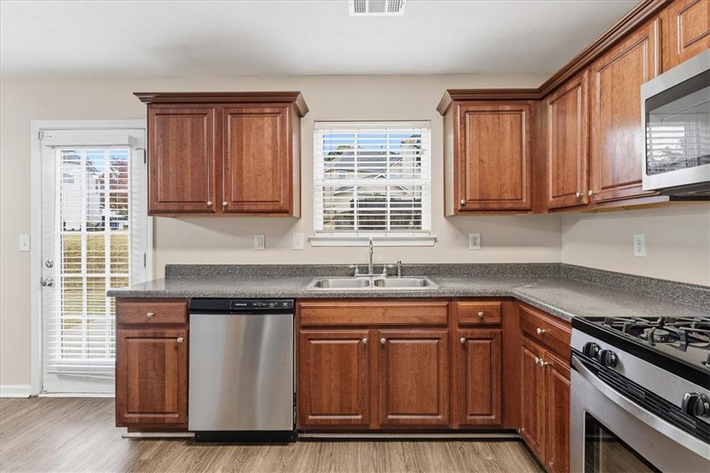 2827 Riders Court Northeast Dacula, GA 30019 - Photo 12 of 41 a kitchen with granite countertop wooden cabinets and a stove top oven