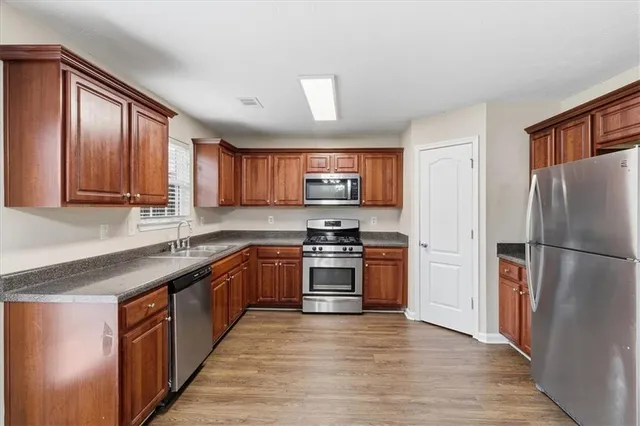 a kitchen with stainless steel appliances granite countertop a refrigerator stove and sink