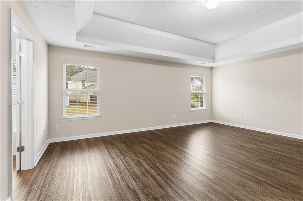 2827 Riders Court Northeast Dacula, GA 30019 - Photo 19 of 41 an empty room with wooden floor and windows