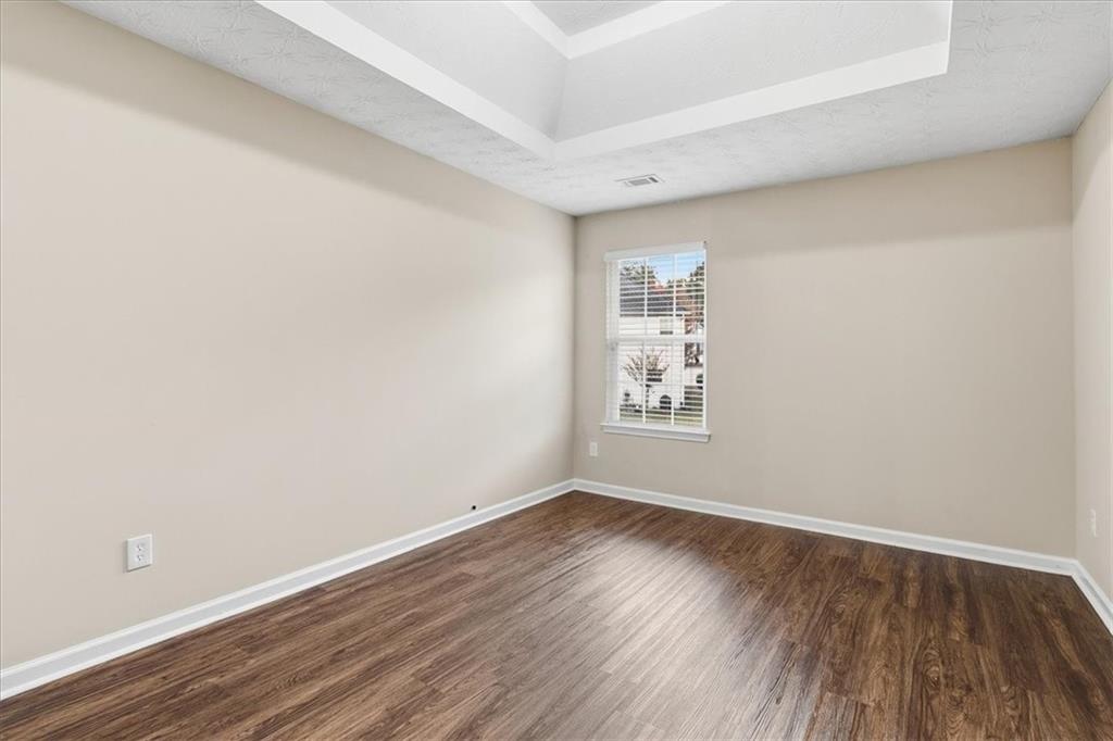 2827 Riders Court Northeast Dacula, GA 30019 - Photo 29 of 41 an empty room with wooden floor and windows