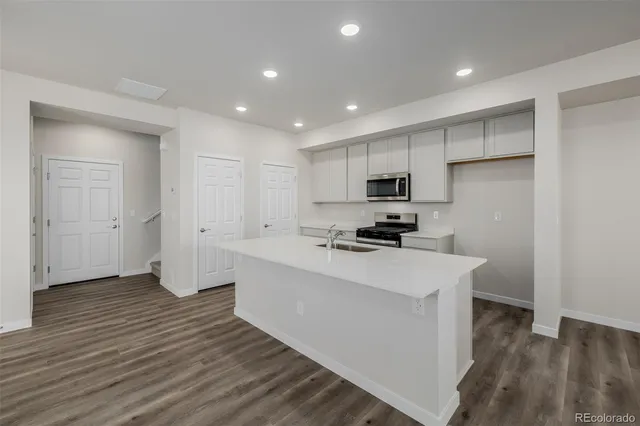 a kitchen with a sink a refrigerator and cabinets