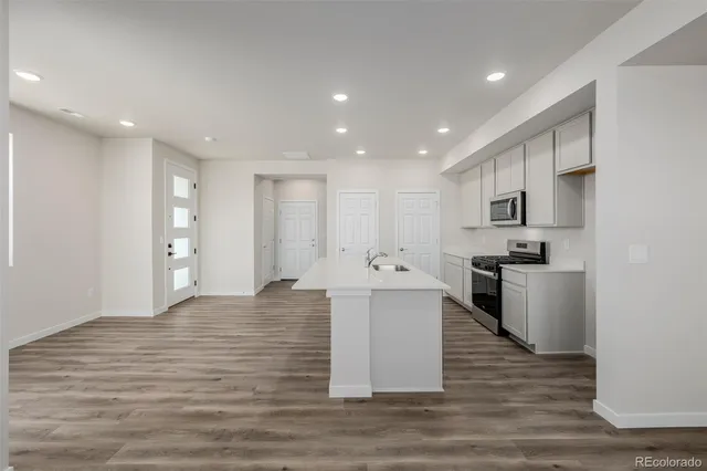 a view of kitchen with stainless steel appliances granite countertop cabinets and wooden floor