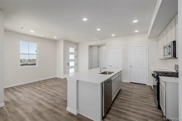 a kitchen with kitchen island a sink and wooden floor