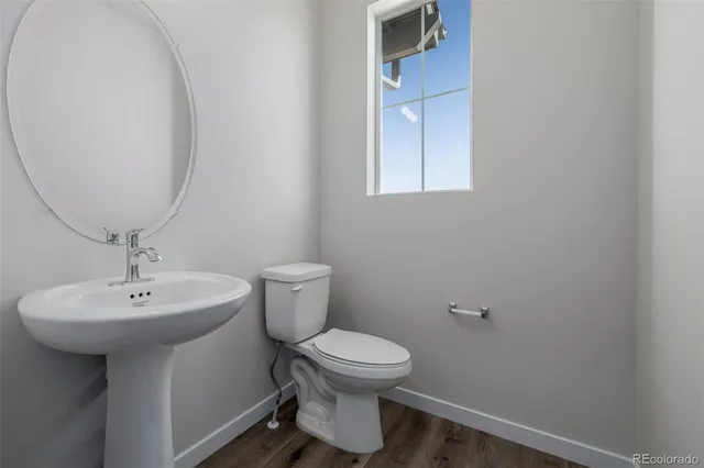 a bathroom with a toilet a sink and mirror