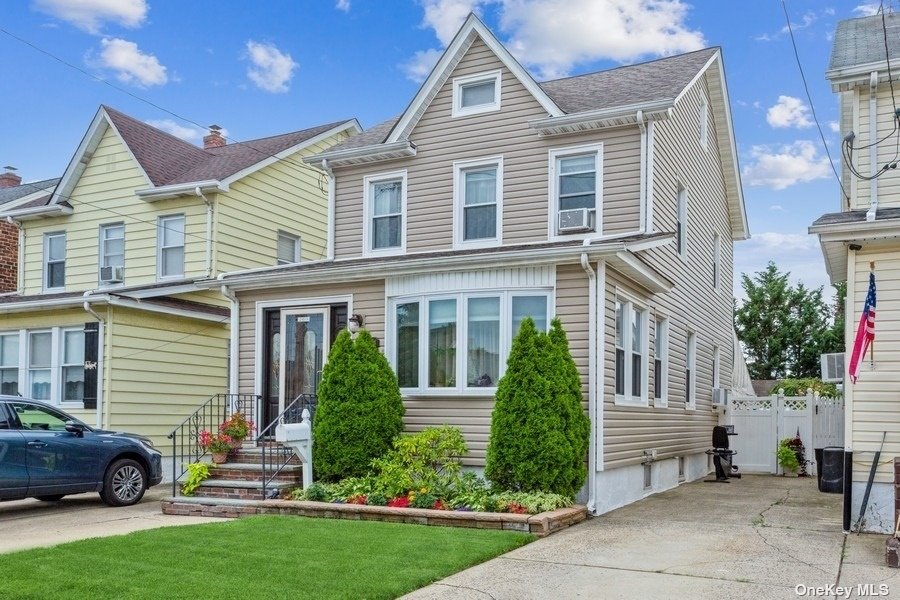 a front view of a house with a garden and plants