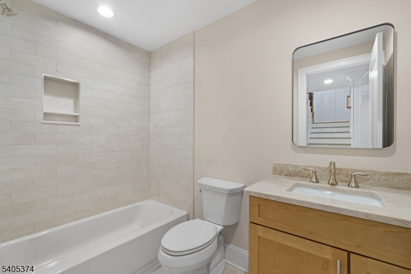 502 Tiffany Way Watchung, NJ 07069 - Photo 33 of 41 a bathroom with a granite countertop toilet a sink and a bathtub