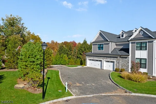 a view of a big house with a big yard plants and large trees