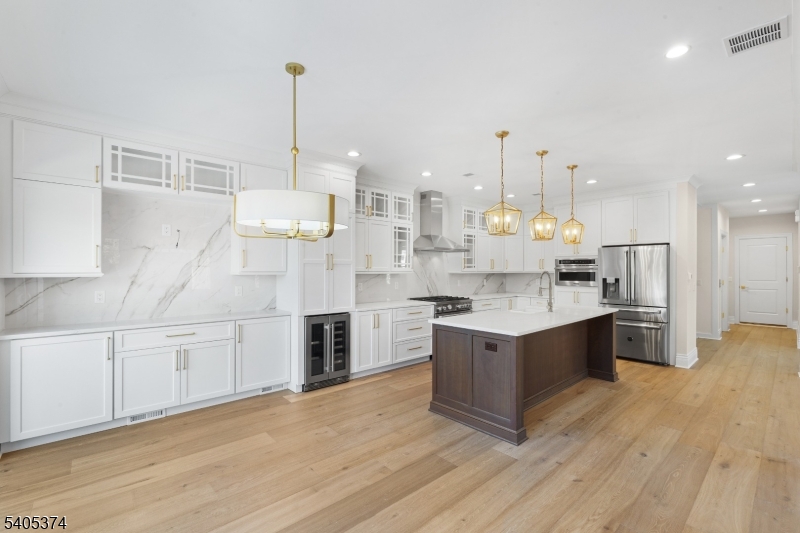 502 Tiffany Way Watchung, NJ 07069 - Photo 5 of 41 a kitchen with stainless steel appliances granite countertop a sink stove and wooden floor