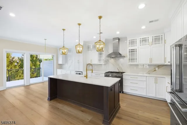 a large kitchen with kitchen island granite countertop a sink a counter space appliances and cabinets