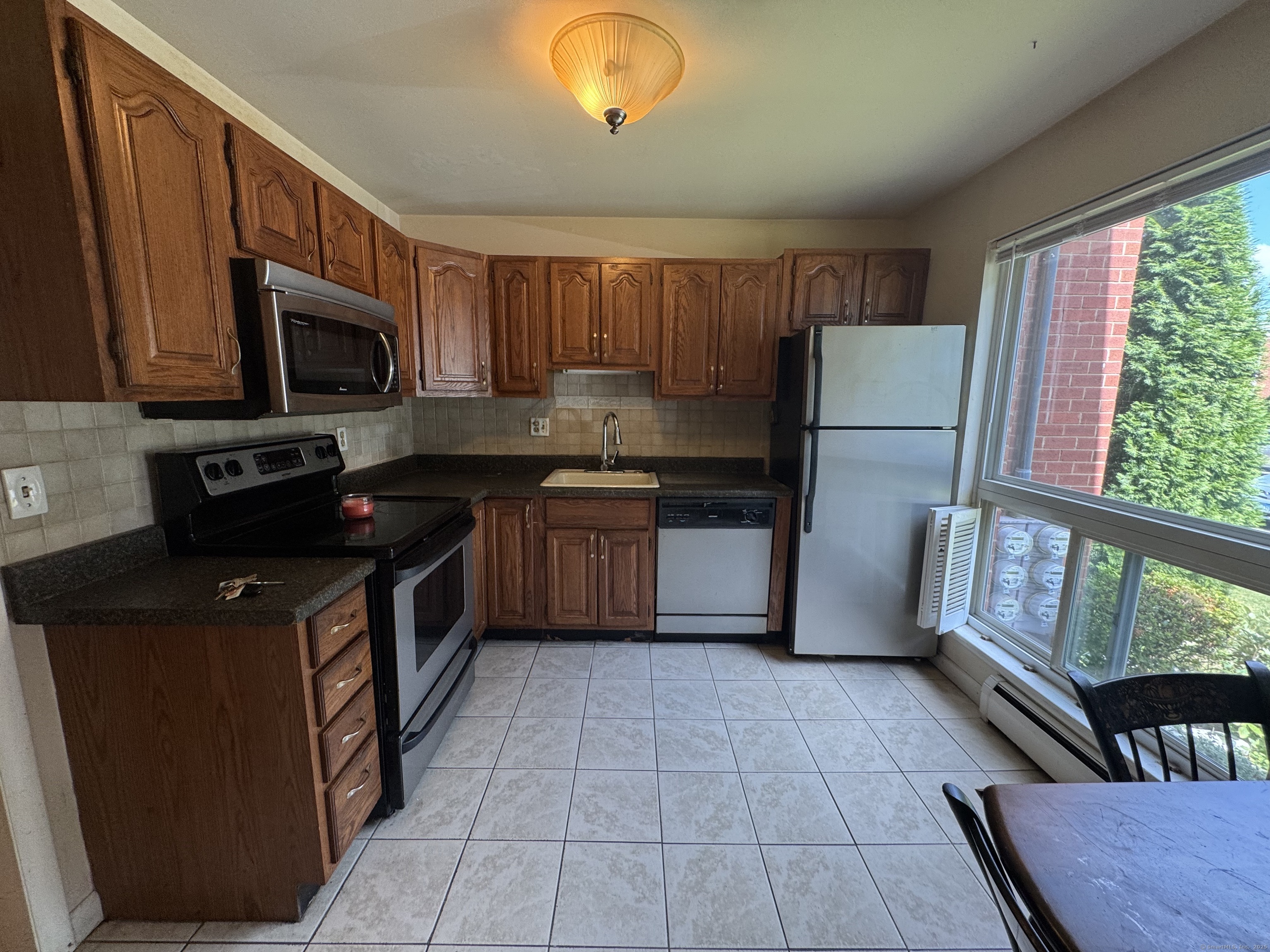 141 Worth Avenue Hamden, CT 06518 - Photo 6 of 17 a kitchen with a sink a stove top oven a refrigerator cabinets and a window