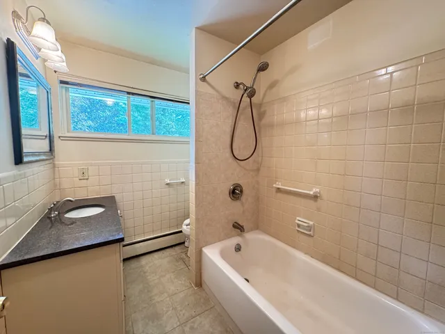 a bathroom with a tub a sink and a window