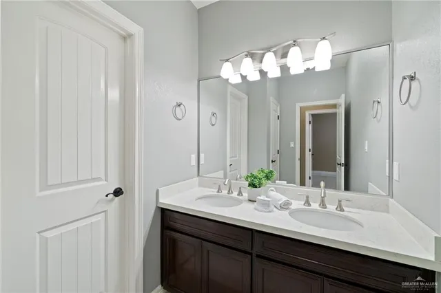 a bathroom with a sink vanity granite shower and a mirror