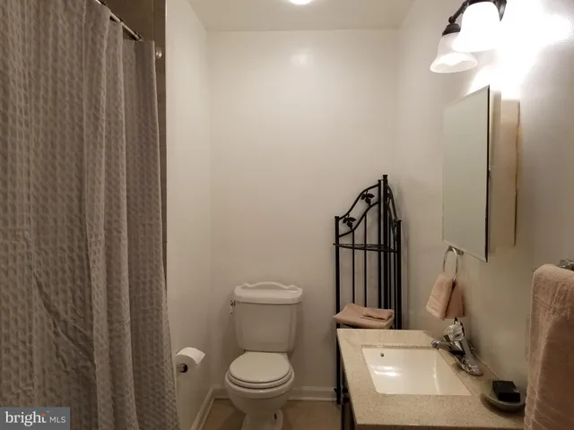 a bathroom with a toilet a sink and mirror