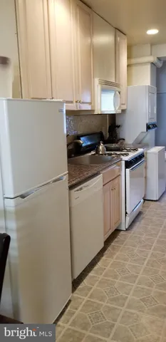 a kitchen with stainless steel appliances a refrigerator sink and white cabinets