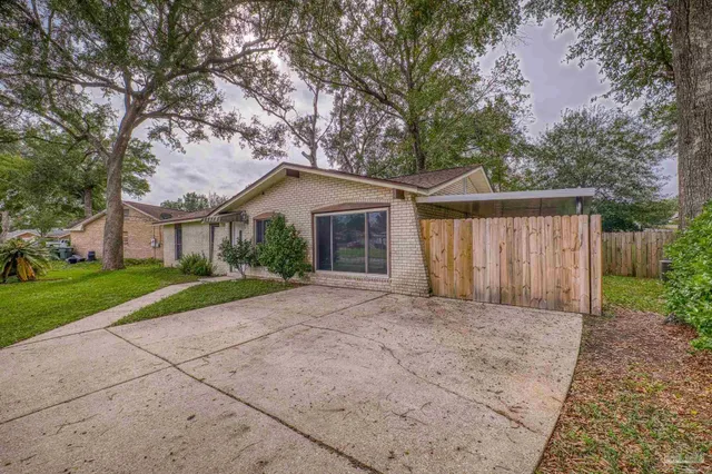 a view of a house with a yard and large tree
