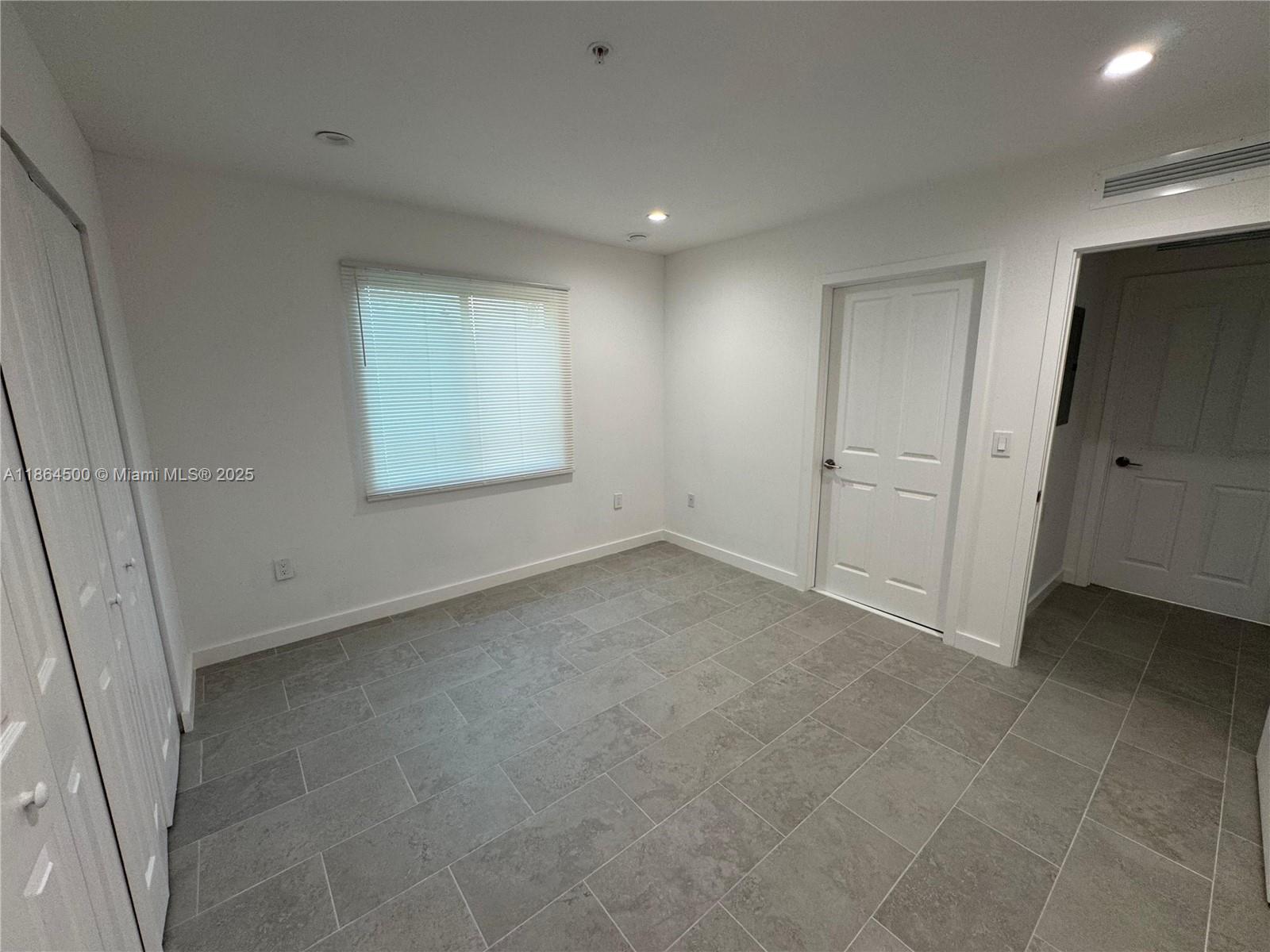 2782 Northwest 46th Street, Unit 5 Miami, FL 33142 - Photo 12 of 18 a view of an empty room with a window