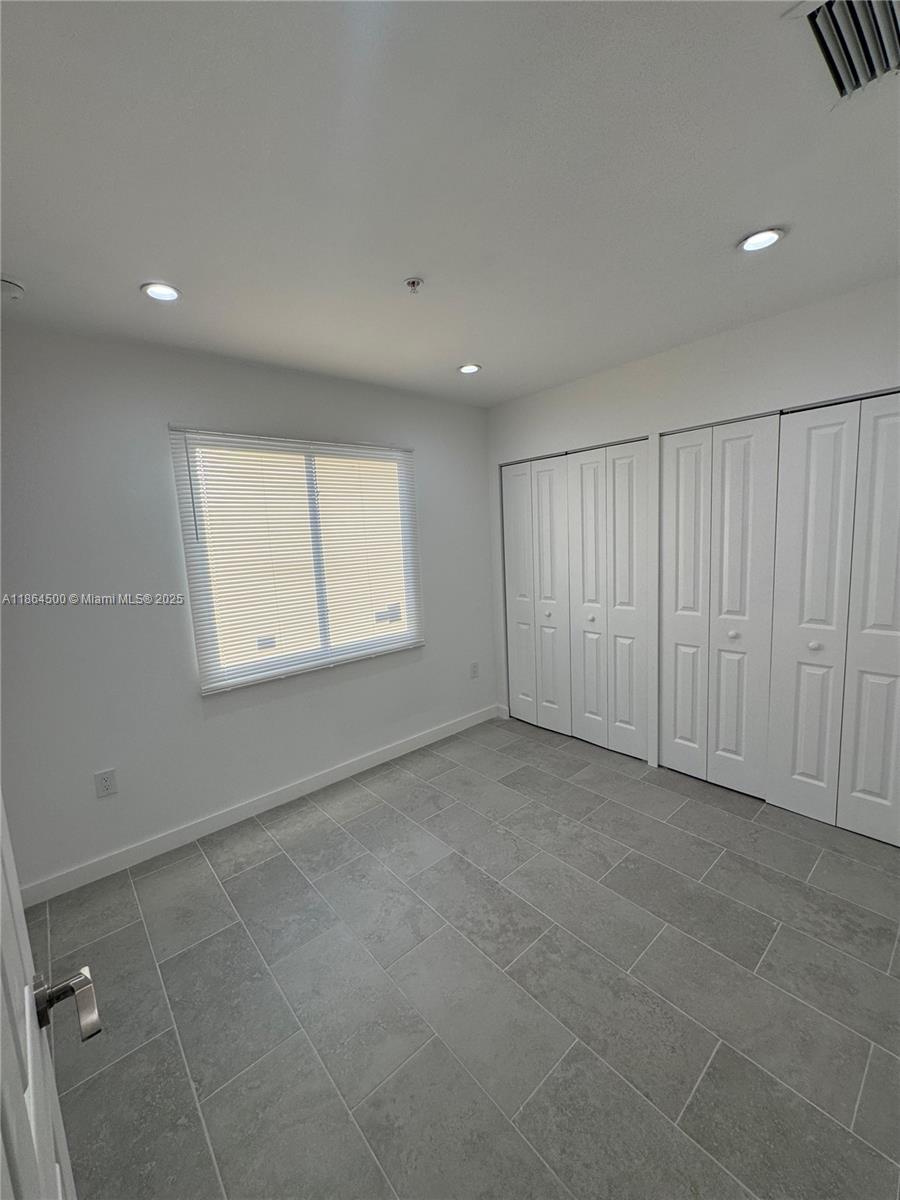 2782 Northwest 46th Street, Unit 5 Miami, FL 33142 - Photo 13 of 18 an empty room with windows