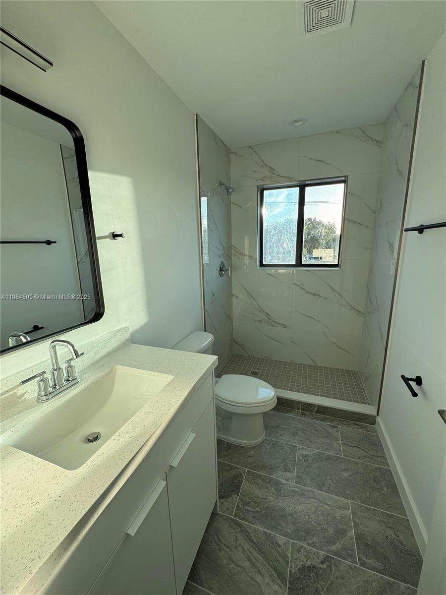 2782 Northwest 46th Street, Unit 5 Miami, FL 33142 - Photo 15 of 18 a bathroom with a sink a toilet and shower