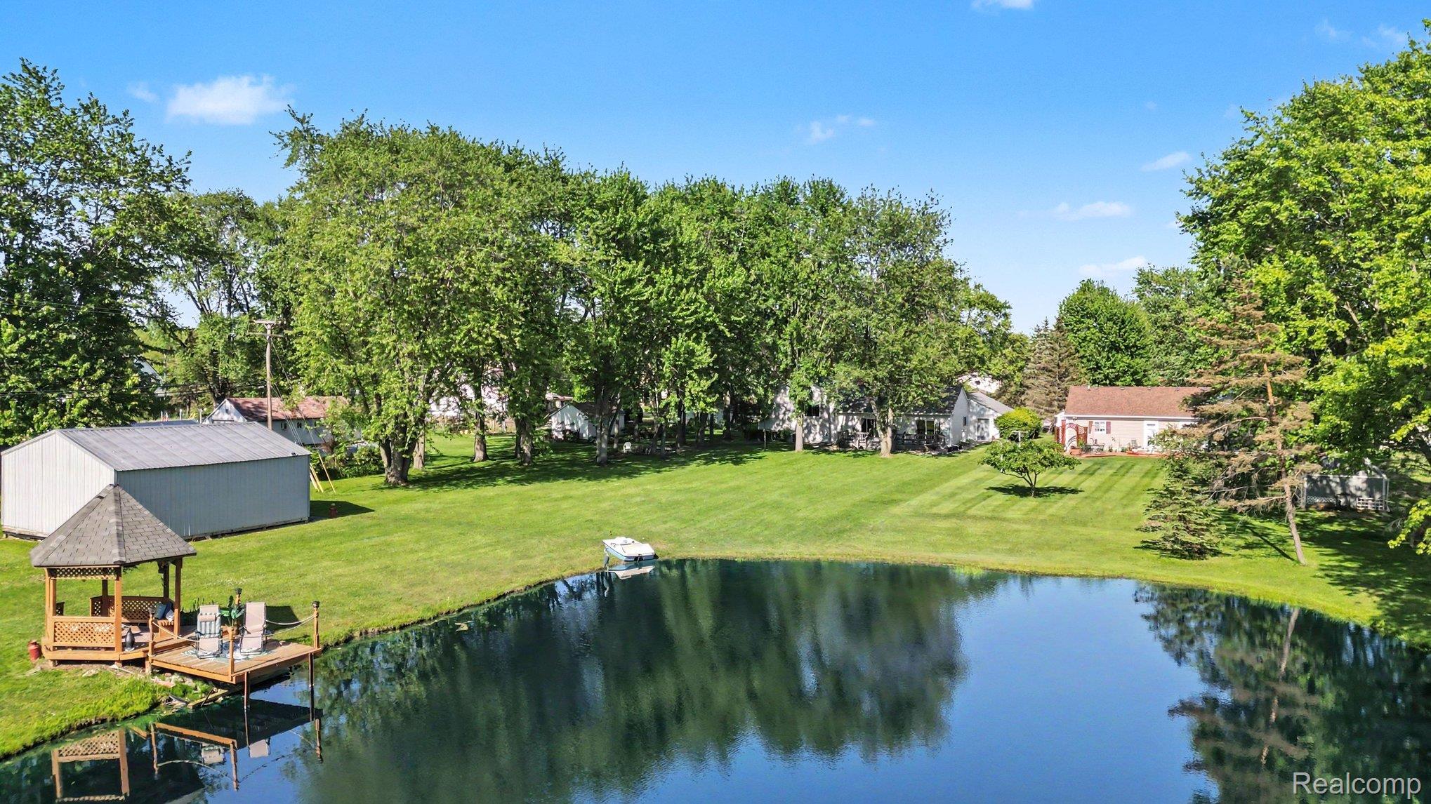 7020 Meldrum Road Fair Haven, MI 48023 - Photo 37 of 43 Expansive property featuring a private pond with a wooden dock and a covered gazebo