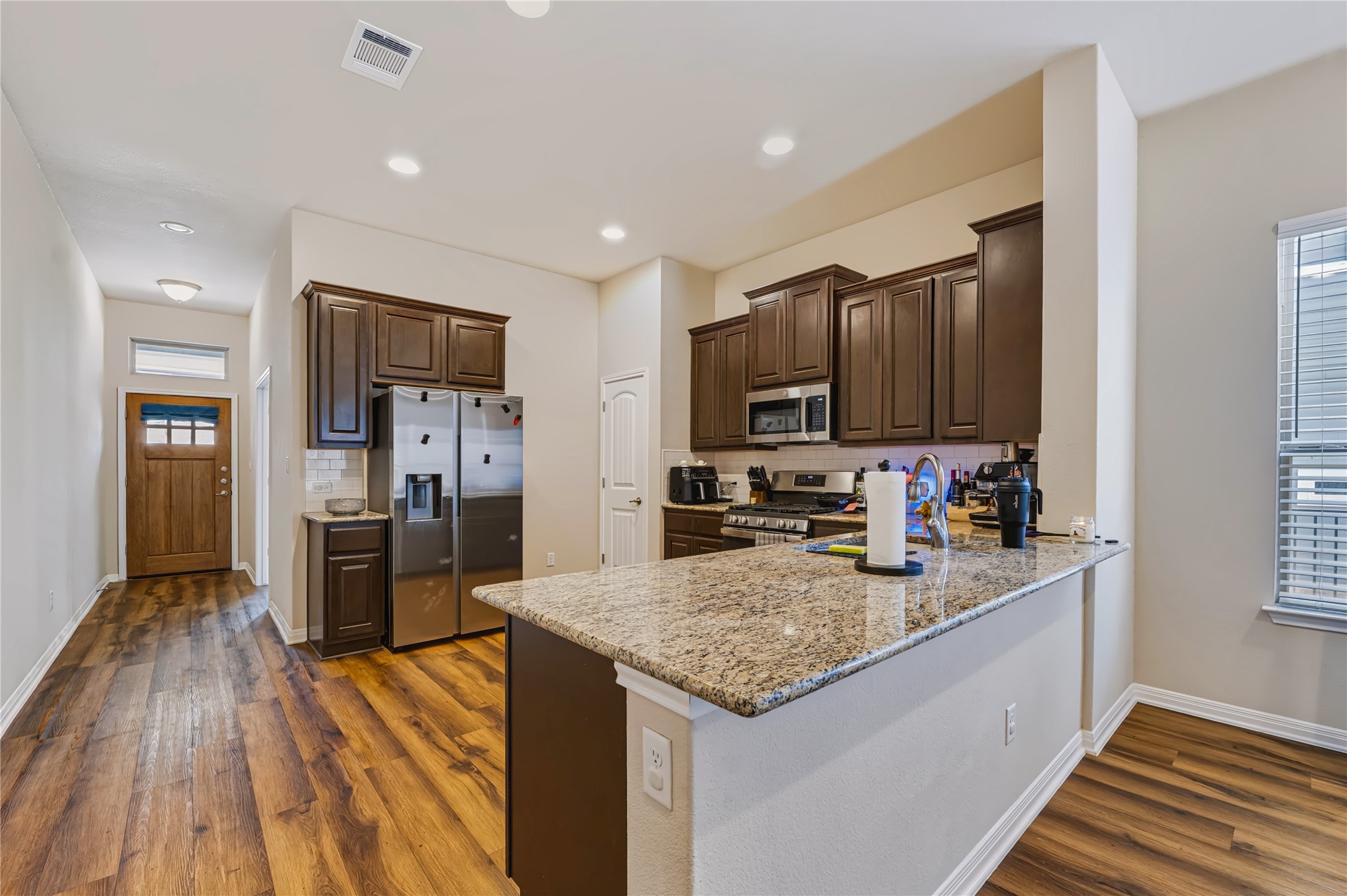 162 Rains Kyle, TX 78640 - Photo 8 of 32 Kitchen featuring rich wood cabinetry, polished stone countertops and recessed lighting