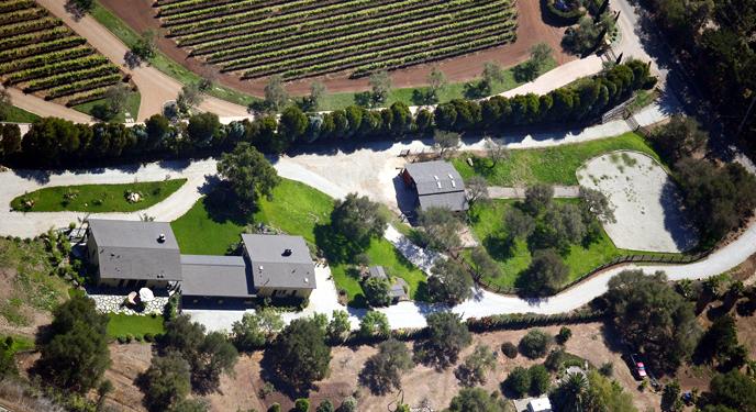an aerial view of a house with a garden and swimming pool