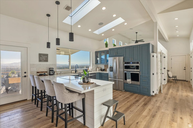 1800 Spring Oaks Drive Springville, UT 84663 - Photo 17 of 68 Kitchen featuring hanging light fixtures, a peninsula, a kitchen bar, stainless steel appliances, and high vaulted ceiling
