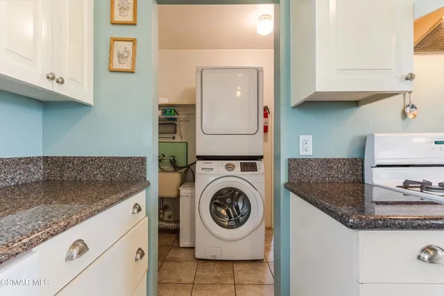 a kitchen with granite countertop cabinets and washing machine