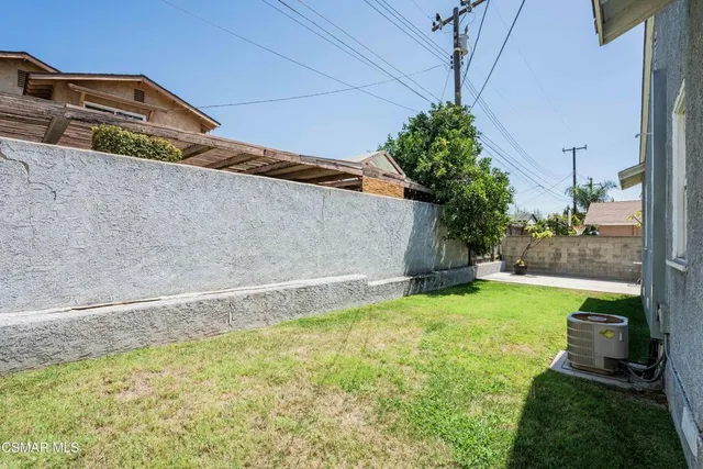 a yellow and white house with a large pool