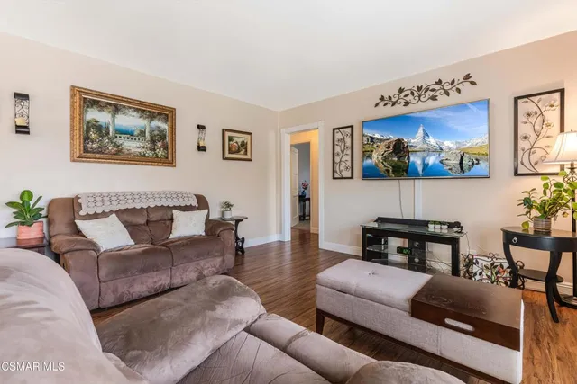 a living room with furniture a couch and paintings on the wall